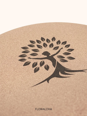 Auf diesem Foto siehst Du eine Nahaufnahme der ovalen Yogamatte Kork. Das Logo ist eine kraftvolle Frau als Baum, sie steht für die Lebensenergie und die Kraft, die die Marke FLOWALOHA gegründet von Jasmin Patricia Kremer repräsentiert. Die Marke ist bekannt von der YogaWorld, von YogaAktuell und vom Gründerpreis BW 2024.